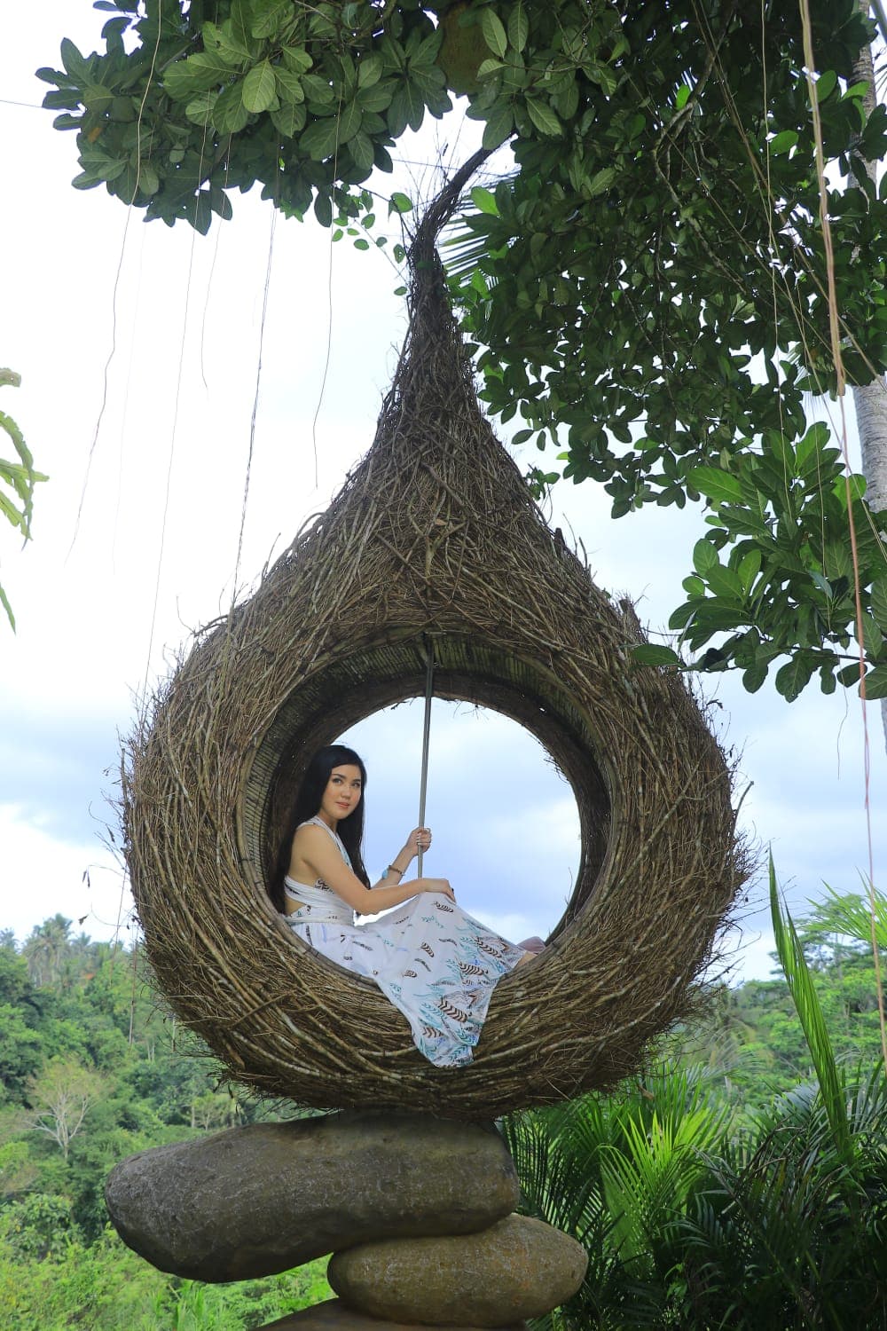 Guest in a yellow dress in the bird nest at Aloha Ubud Swing