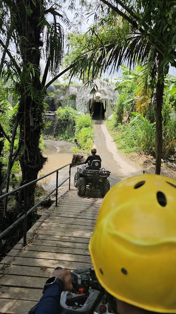 Rider POV following another ATV across a wooden jungle bridge