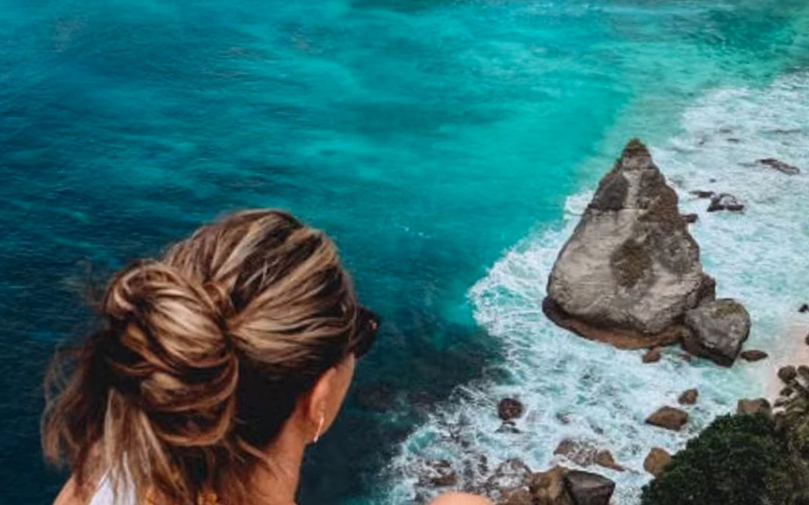 Guest on a Bali clifftop looking over turquoise water on a private itinerary