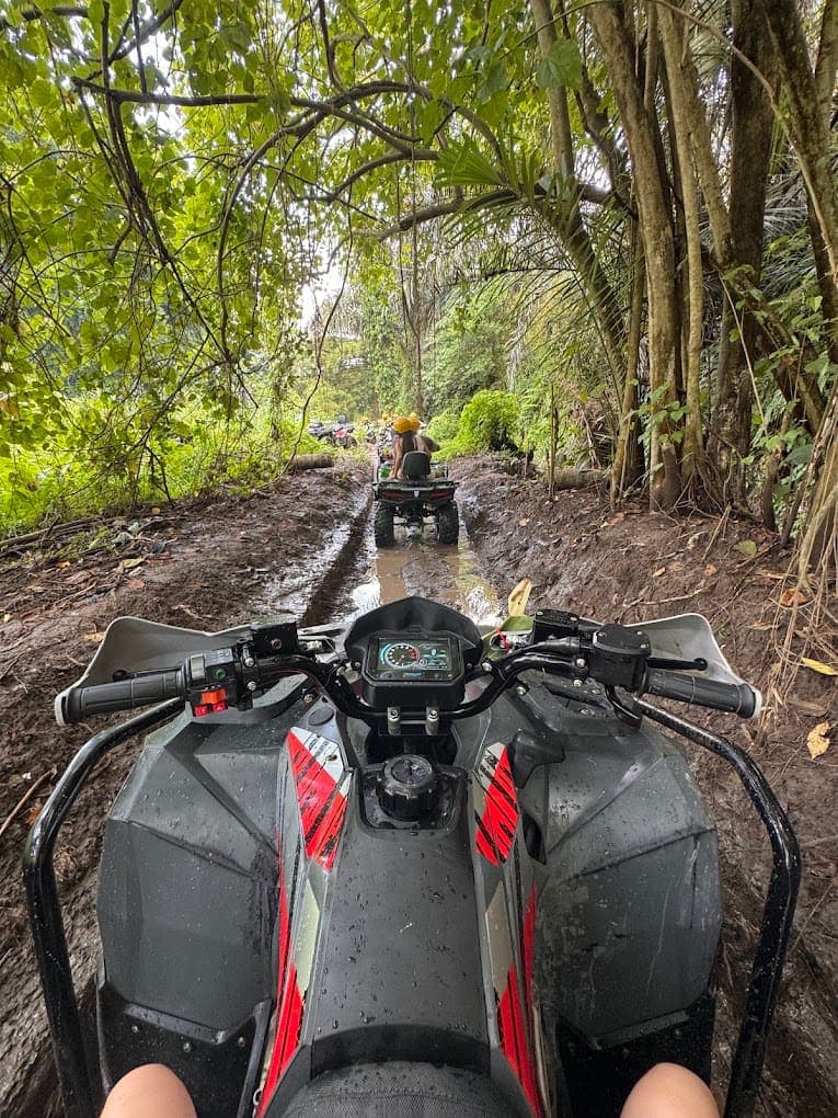 Rider POV of a muddy jungle ATV track near Ubud