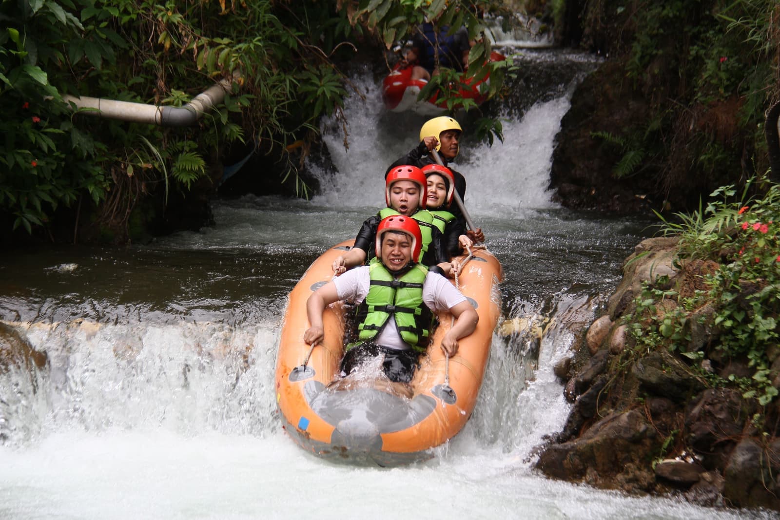 Wos River canyon tubing group dropping a small waterfall near Ubud